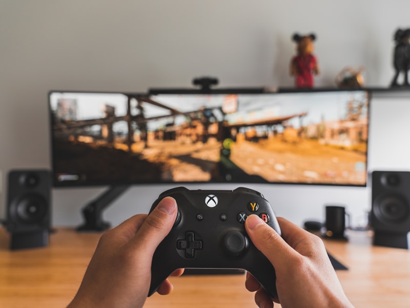 Hands reviewing a game controller on a wooden bench